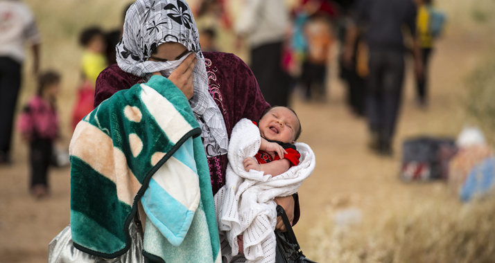 Es sind Tränen der Erschöpfung und Erleichterung, die diese junge Syrerin verbirgt. Auf der Flucht vor dem syrischen Bürgerkrieg hat sie mit ihrem erst wenige Wochen alten Säugling gerade die kurdische Grenze überquert