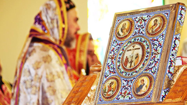 Die reich verzierte Bibel steht auf dem Altar. Im Hintergrund Erzbischof Mattias Nayis beim Vortragen der Liturgie