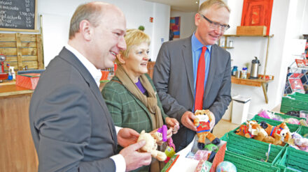 Kai Wegner (CDU), Renate Künast (Bündnis 90/Die Grünen) und Klaus Mindrup (SPD) packen symbolisch einen Schuhkarton mit Geschenken für Kinder