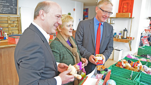 Kai Wegner (CDU), Renate Künast (Bündnis 90/Die Grünen) und Klaus Mindrup (SPD) packen symbolisch einen Schuhkarton mit Geschenken für Kinder