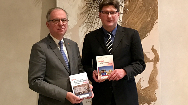 Der CDU-Bundestagsabgeordnete Heribert Hirte (links), Vorsitzender des Stephanus-Kreises der CDU/CSU-Bundestagsfraktion, nimmt das Jahrbuch aus den Händen von Uwe Heimowski entgegen