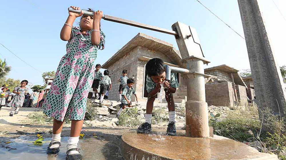 Kinder in Indien zapfen Wasser mit einer von wortundtat installierten Pumpe, die sauberes Grundwasser fördert