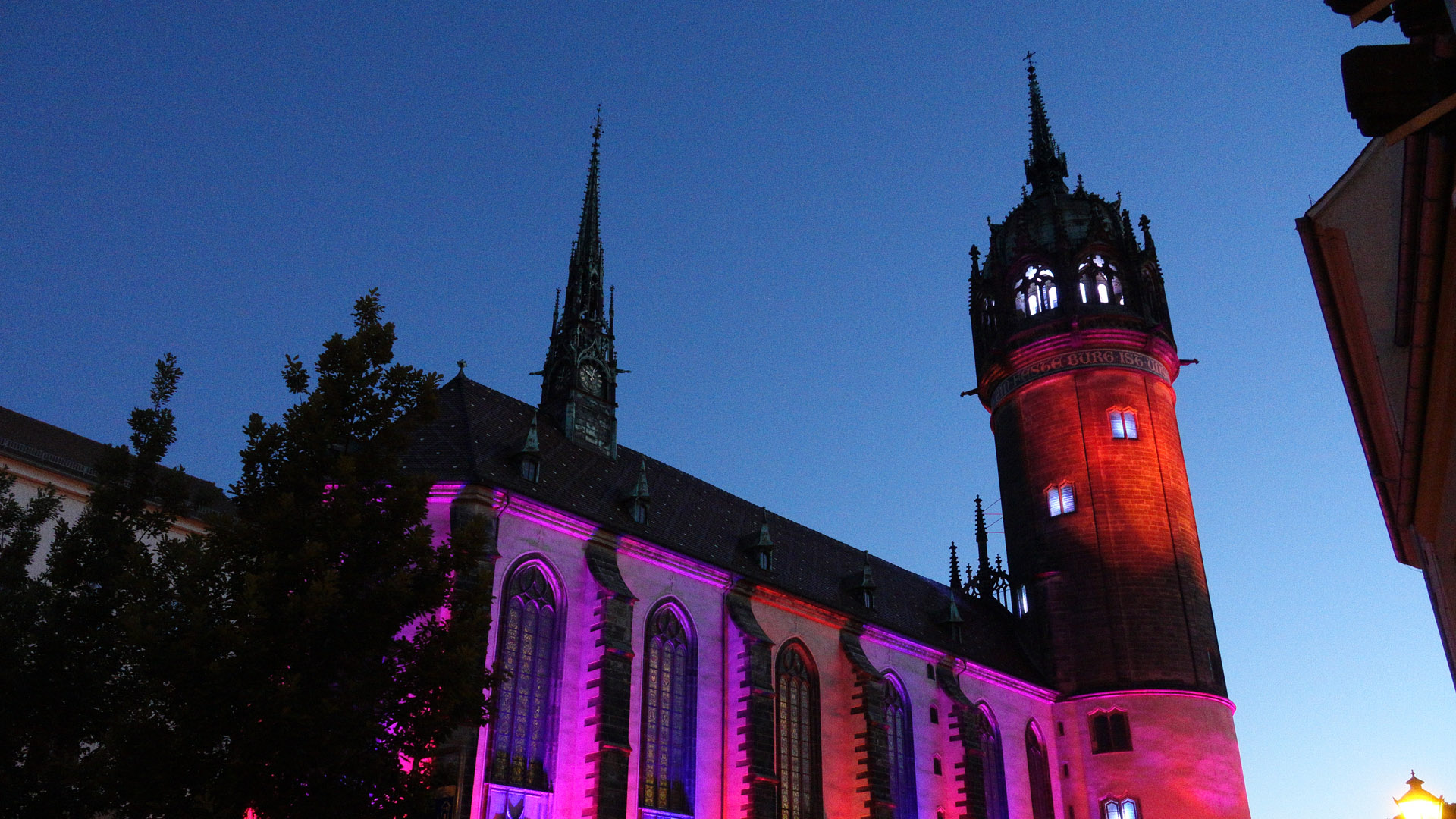 ... die Schlosskirche, an deren Tür Luthers Thesen angeschlagen worden sein sollen, war in rötlich-violette Töne getaucht