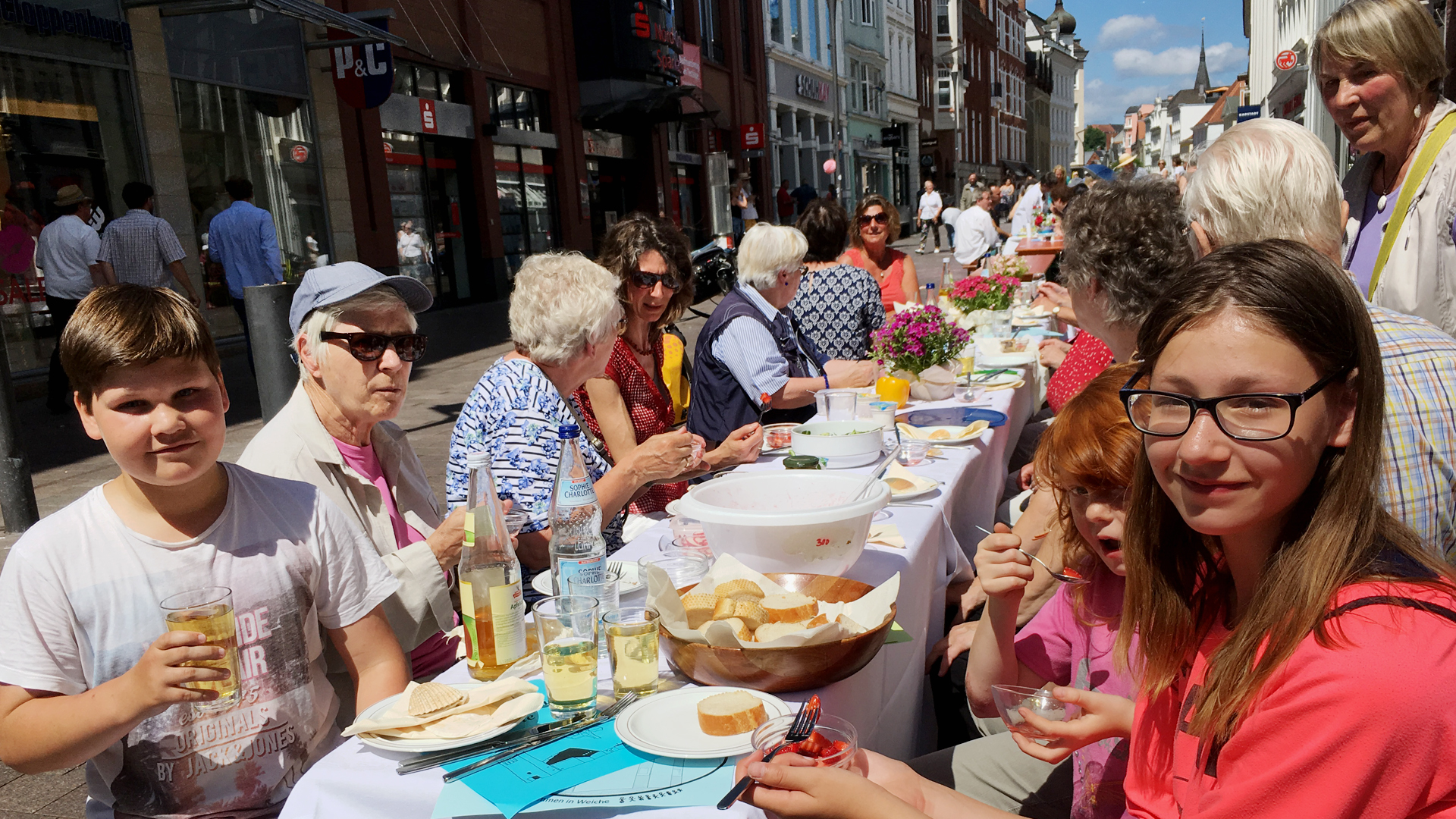 Kinder und Senioren genießen die Gemeinschaft. Zwischen den Tischen der fast einen Kilometer langen Tafel ist immer wieder Platz gelassen für Rettungswege.