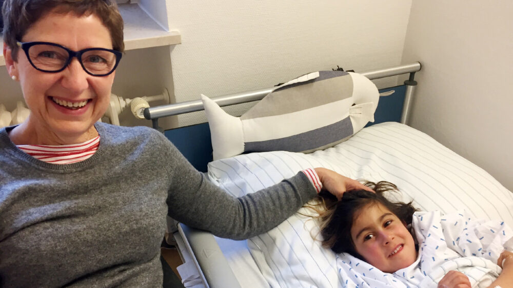 Die Hamburger Gastmutter Brigitte Eichholz sitzt nach der Herz-OP am Krankenhausbett der sechsjährigen Afghanin Aisha