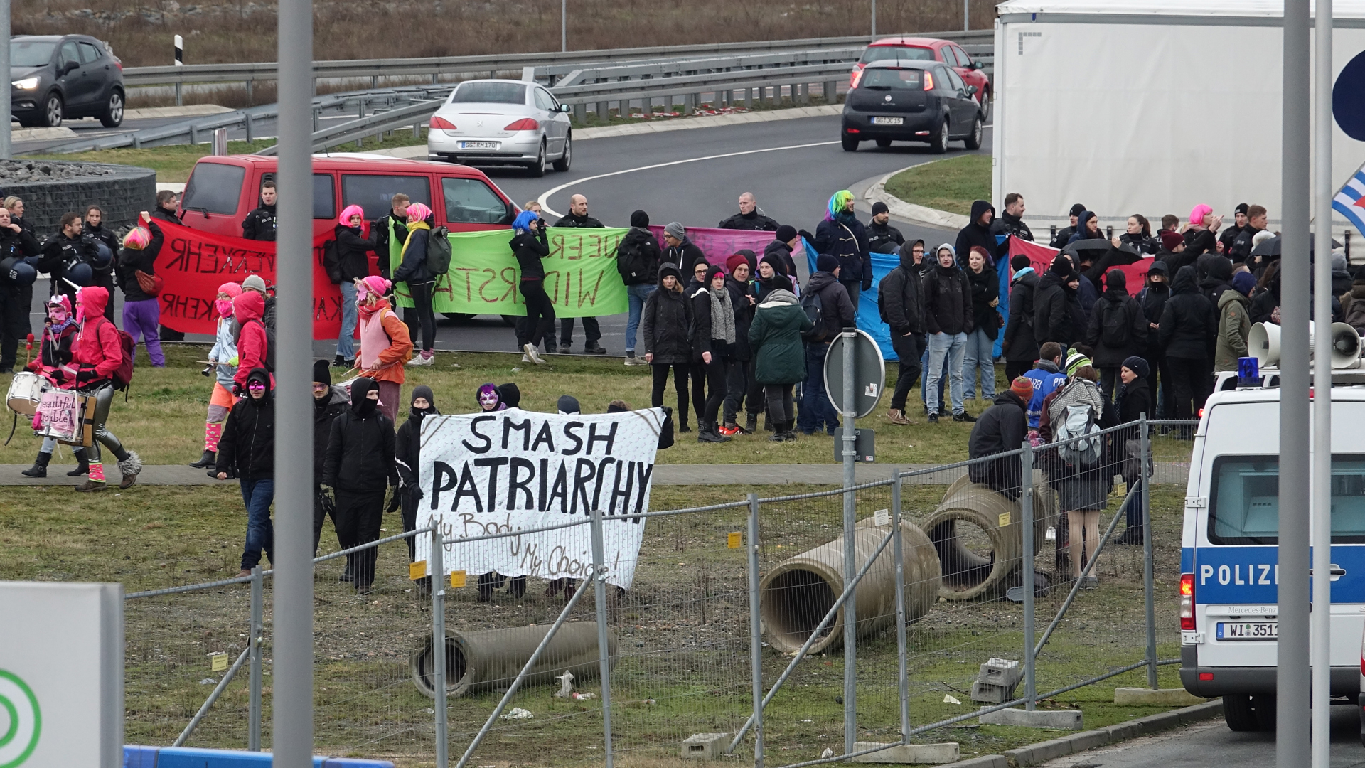 Die Demonstranten erschienen teils schwarz vermummt, teils in pinker Verkleidung. Manche von ihnen pöbelten Teilnehmer auf ihrem Weg ins Kongresszentrum an.