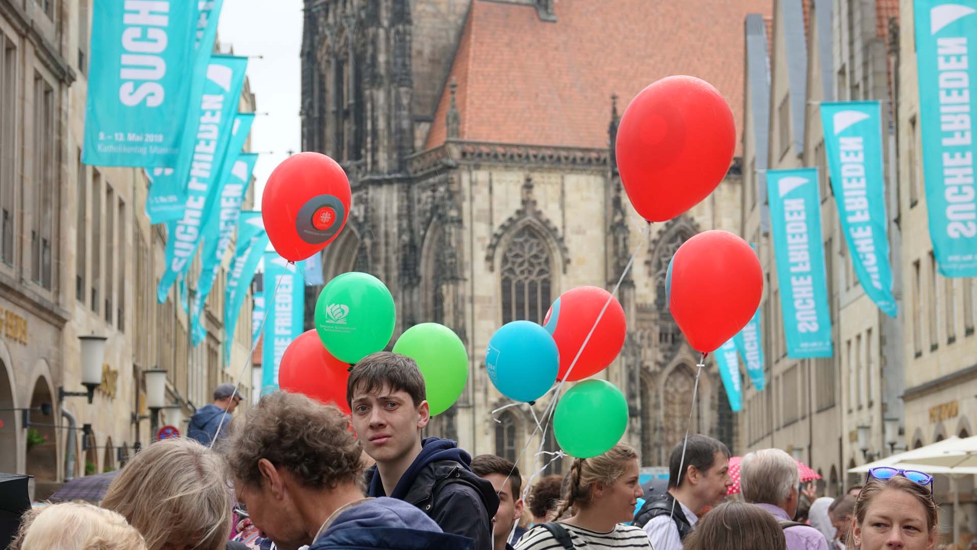 „Suche Frieden“ ist das Motto des diesjährigen Katholikentags. Die Straße Prinzipalmarkt in Münster ist gefüllt von Jugendgruppen, Familien, Einzelbesuchern.