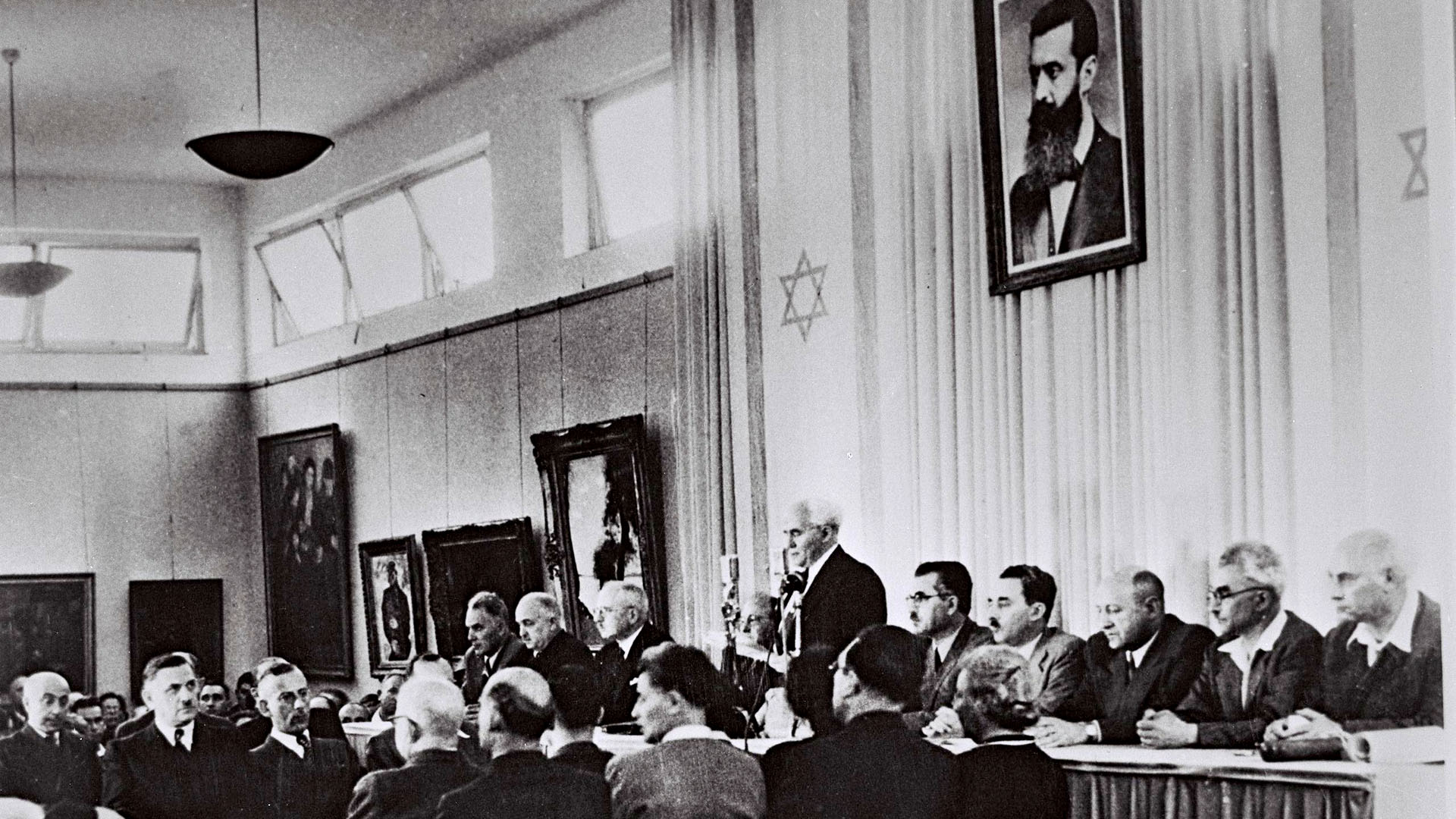 Ben-Gurion verliest die israelische Unabhängigkeitserklärung – über ihm ein Portrait von Theodor Herzl