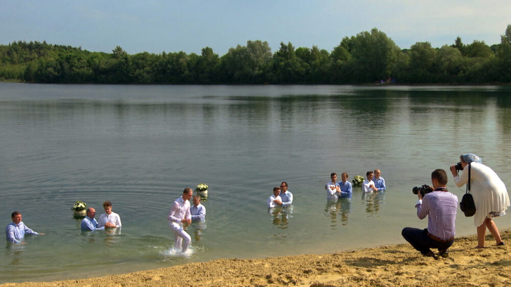 Mitglieder der russlanddeutschen Pfingstgemeinde bei einer Taufe. Der NDR hat sie im Alltag begleitet.