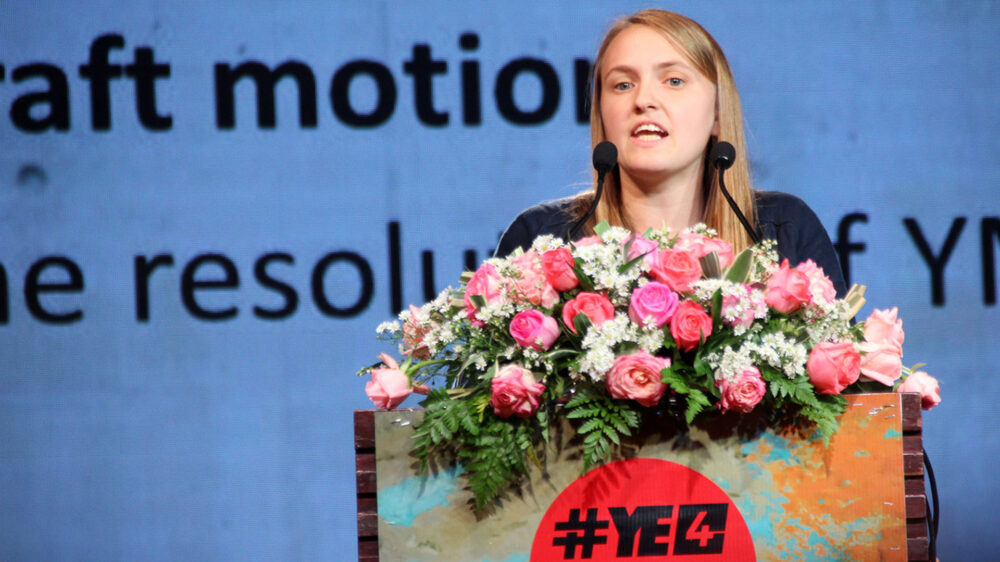 Lena Bade, CVJM Berlin und Mitglied der deutschen Delegation, stellt die Resolution zur Abstimmung dem CVJM-Weltrat vor