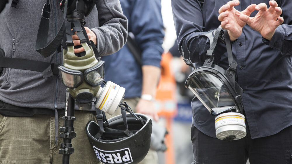 Pressevertreter mit Gasmasken: nicht überall ist die Ausführung des Journalisten-Berufs ohne Gefahren möglich