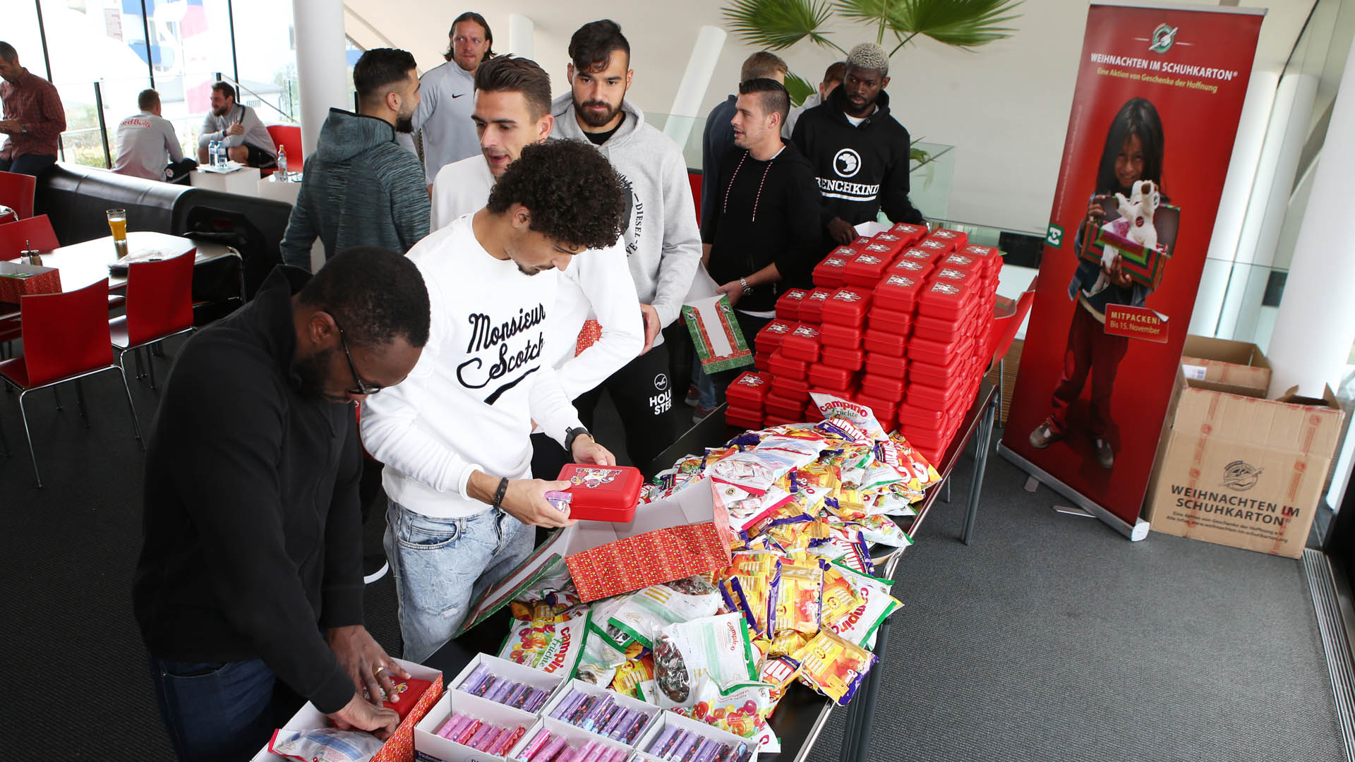 Reinhold Yabo (vorn links) und seine Teamkollegen packen Geschenkkartons