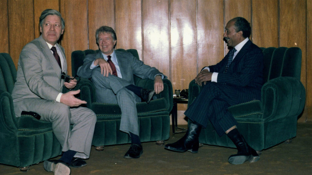 Über den Jahreswechsel 1977/78 besuchte der damalige Bundeskanzler Helmut Schmidt (links) den ägyptischen Präsidenten Anwar as-Sadat. Ihre Gespräche prägten Schmidts Ansichten über das Friedenspotenzial von Religionen. Hier im Bild, das am 4. Januar 1978 entstand, ist zudem US-Präsident Jimmy Carter.