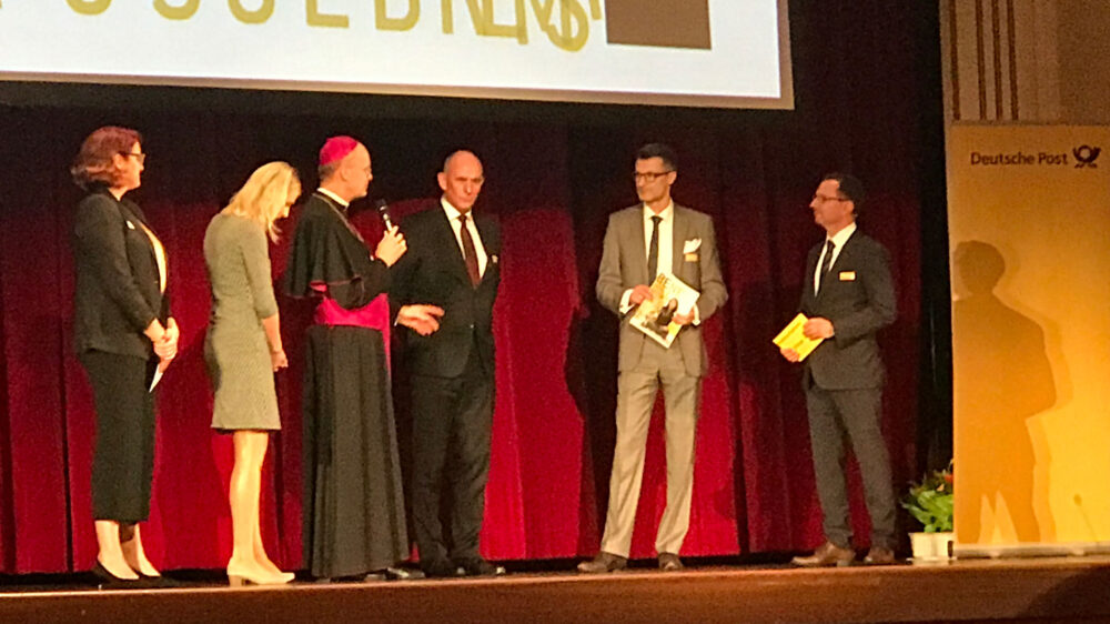 Die Redakteurinnen Kathrin Brüggemann, Sandra Gerke und Bischof Franz-Josef Overbeck nehmen den Preis entgegen.