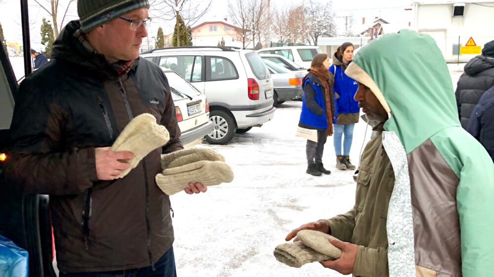Bei klirrender Kälte hilft Uwe Heimowski (links) im Flüchtlingslager beim Verteilen warmer Socken
