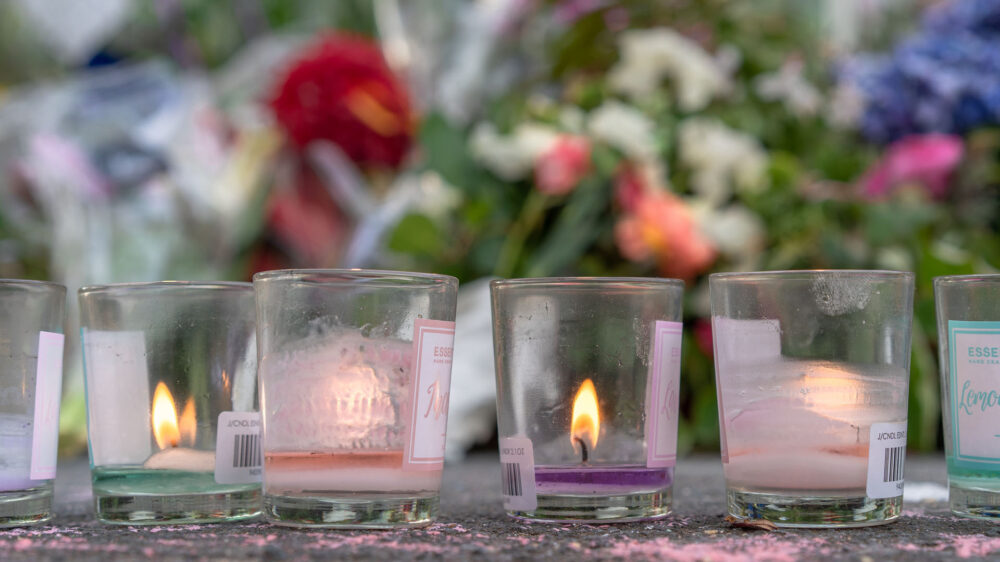 Kerzen und Blumen sind Symbole des Trauerns