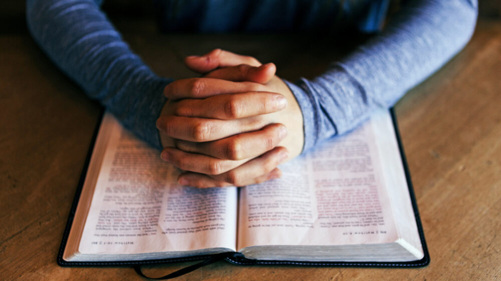Ein Mensch, der beim Bibellesen betet