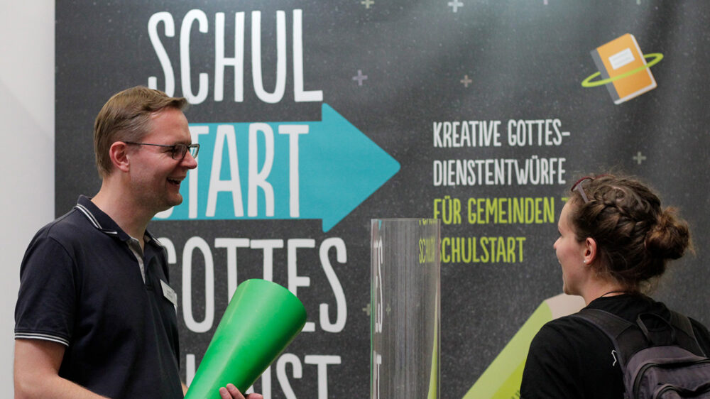 Jürgen Schmidt (links), Leiter der Schüler-SMD, stellt das Projekt auf dem Kirchentag vor