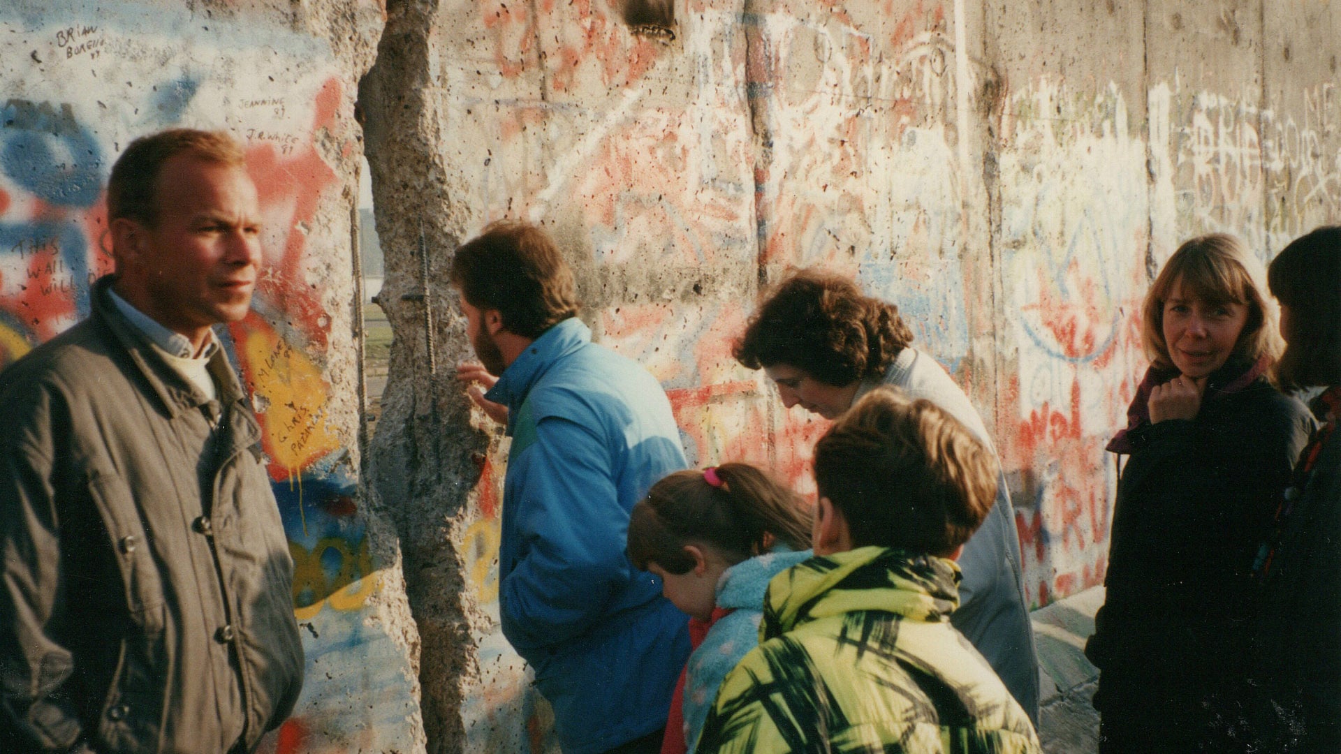Von Westen aus blicken am 11. November 1989 Menschen durch einen Spalt auf den Potsdamer Platz