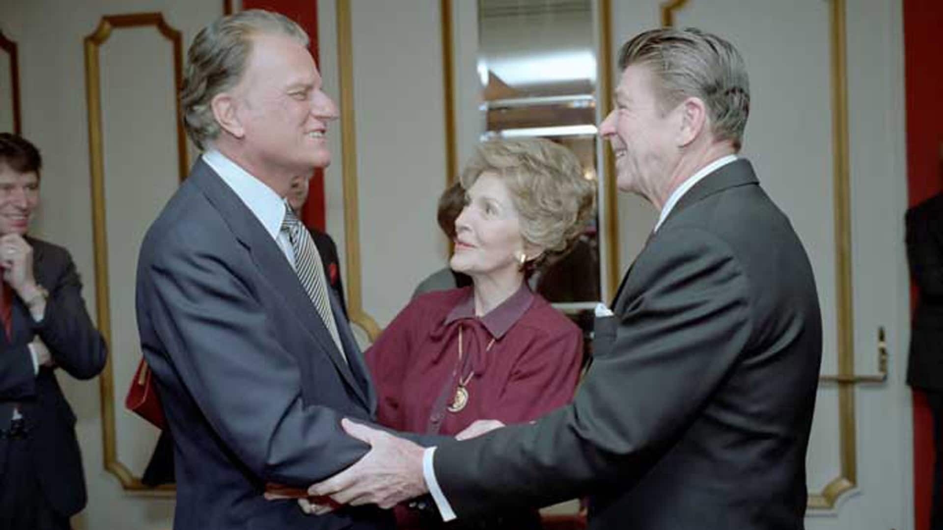 Der Evangelist Billy Graham (links) mit US-Präsident Ronald Reagan und dessen Frau Nancy beim Gebetsfrühstück 1981