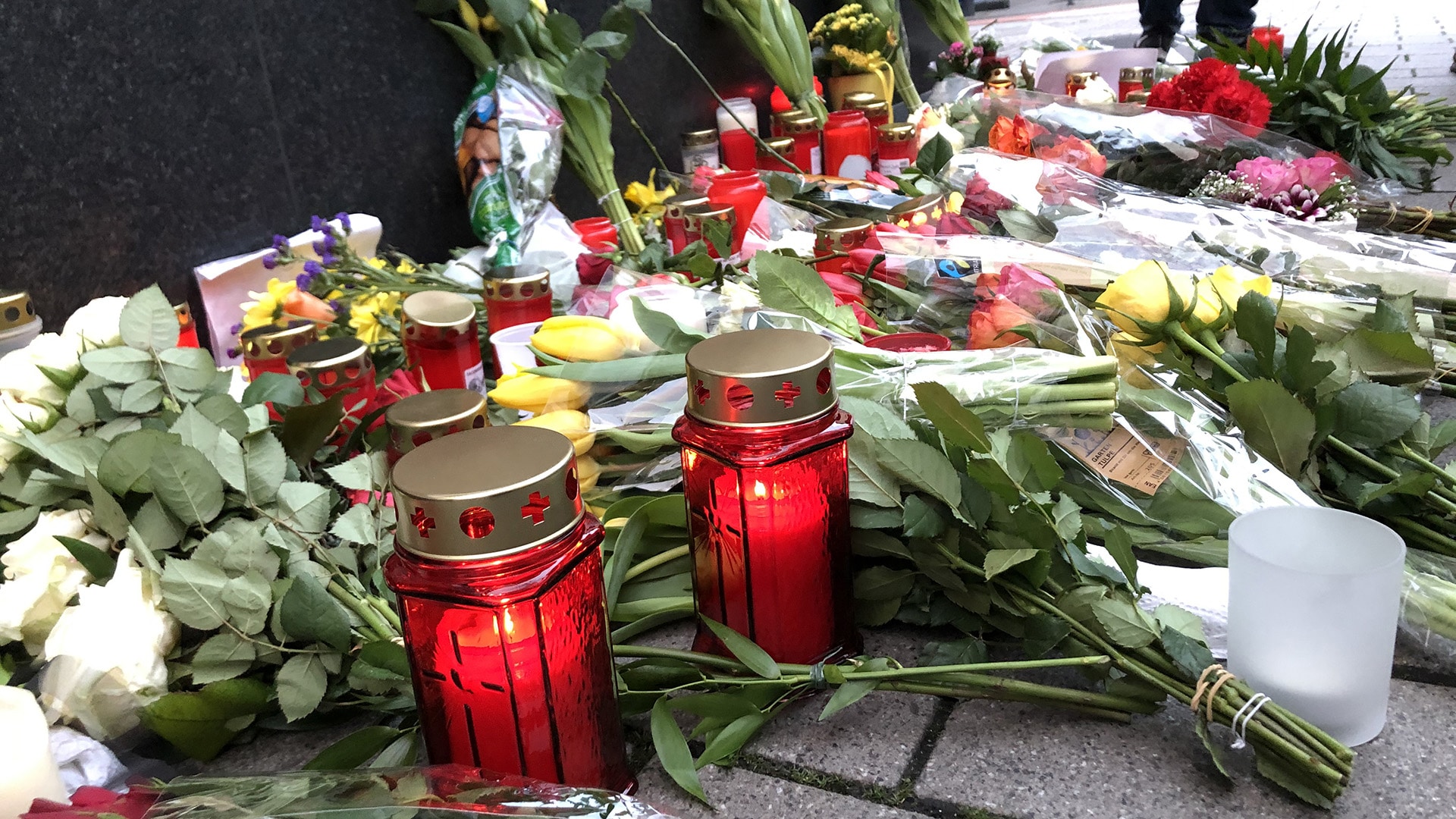 In der Nähe der Shisha-Bar „Midnight“ haben Menschen Blumen und Kerzen auf den Boden gelegt