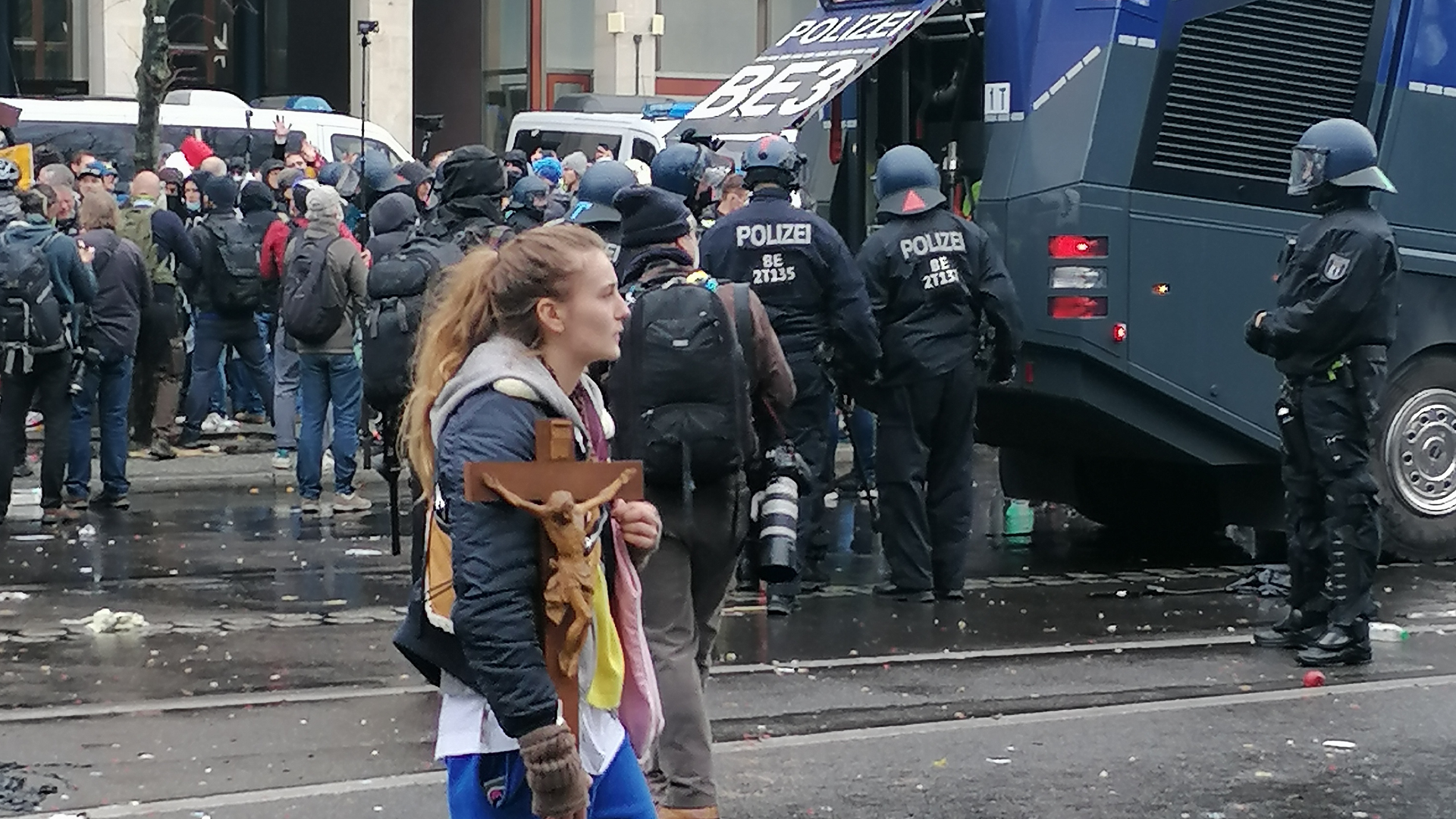 Eine Frau trägt auf einer Corona-Demo ein Kreuz