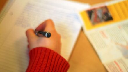 Kind schreibt mit Stift