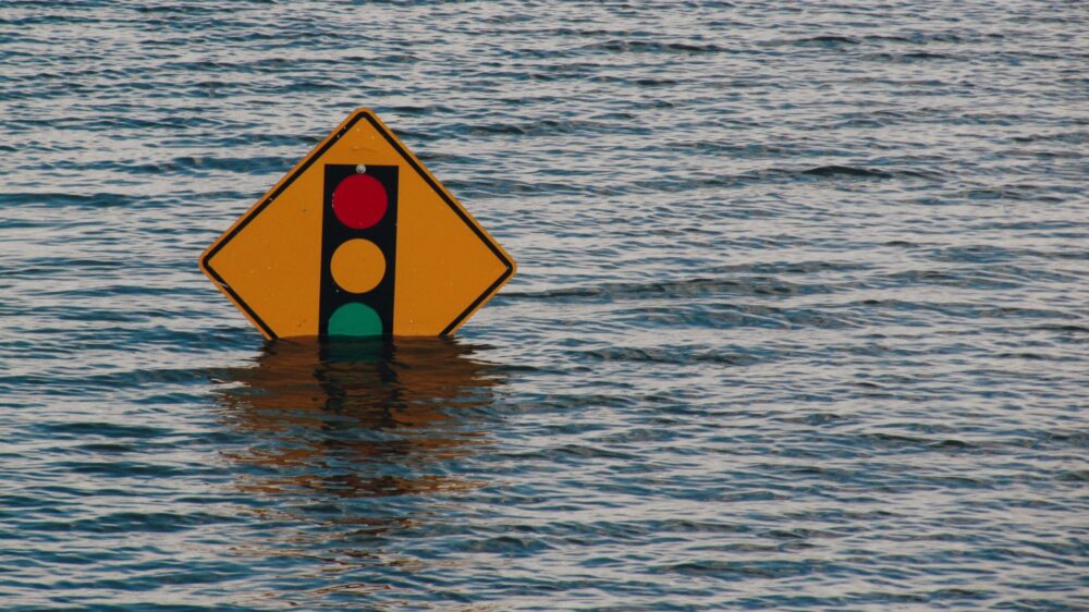 Ein Schild mit einer Ampel im Hochwasser, Klimawandel und Religion
