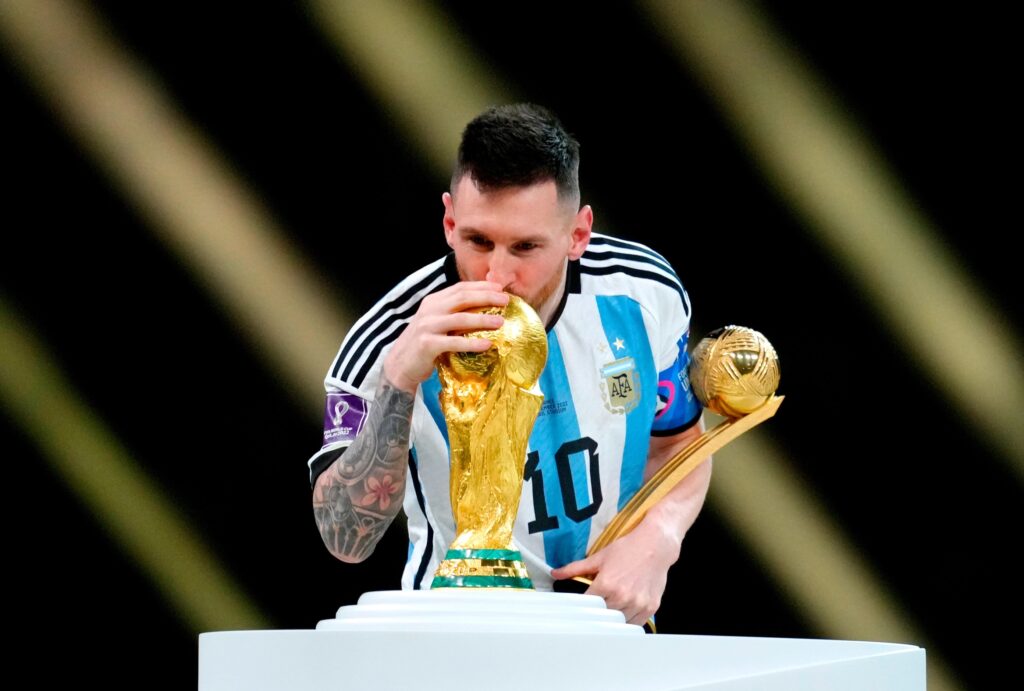 Lionel Messi küsst den WM-Pokal 2022 in Katar