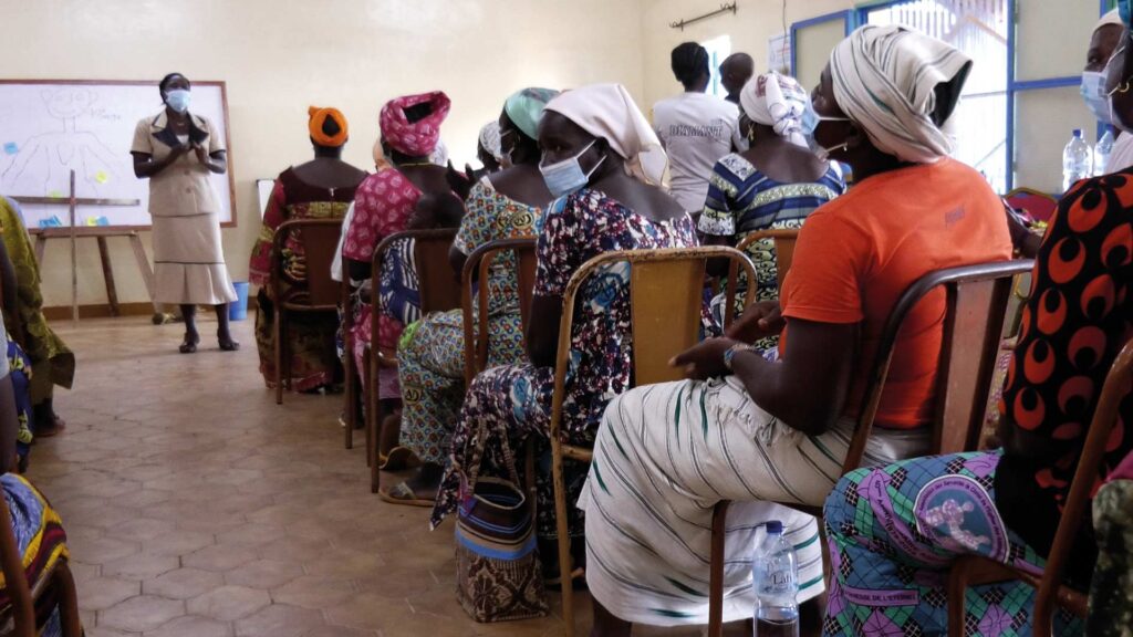 88 Witwen sitzen zusammen in einem Klassenraum und hören einer Referentin zu
