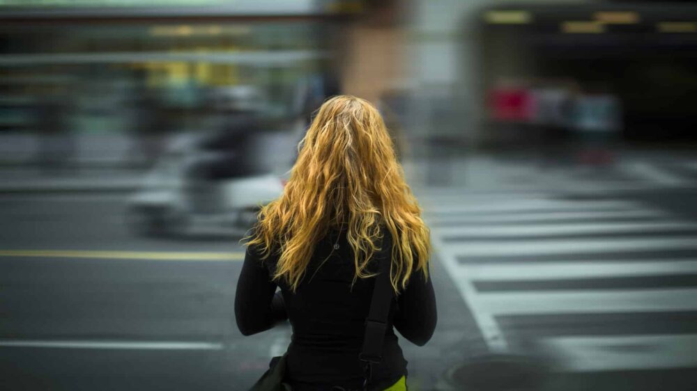 Junge Frau an einer Straße, nachdenklich, einsam