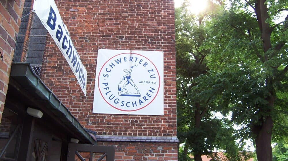 Das Symbol "Schwerter zu Pflugscharen" als Banner an einer Kirche in Greifswald