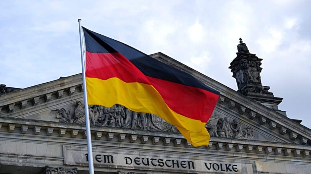 Deutsche Flagge vor dem Reichtagsgebäude in Berlin. Die Inschrift auf dem Archivtrav "Dem Deutschen Volke" ist zu sehen.