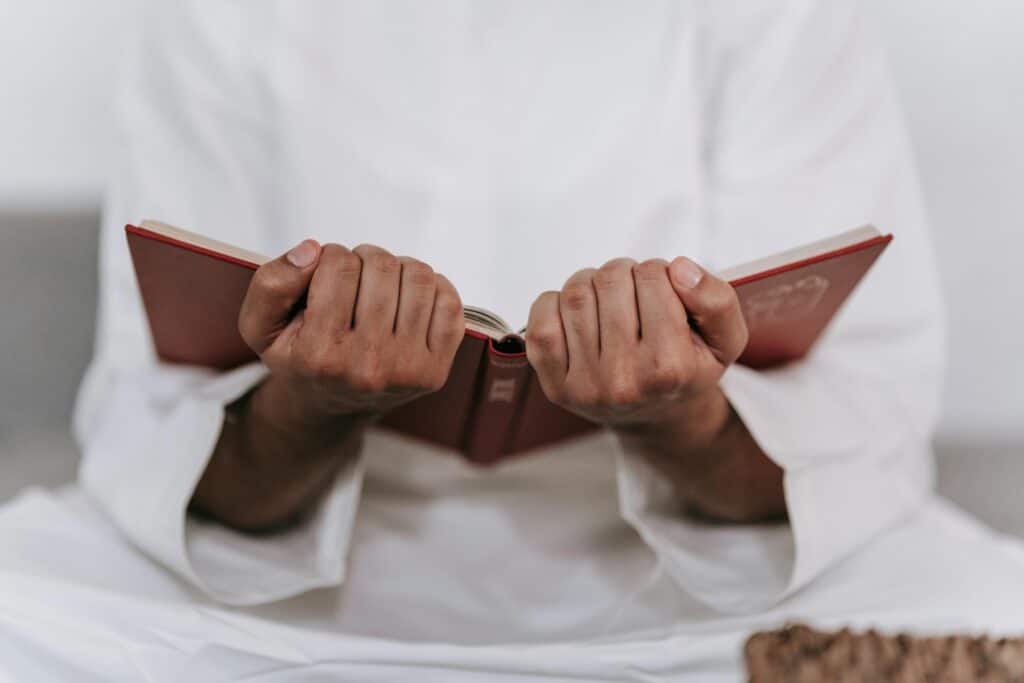 Hände mit aufgeschlagenem Koran-Buch