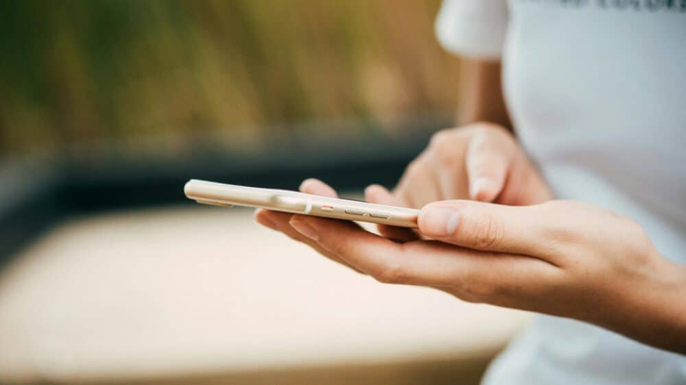 Eine Frau mit einem Smartphone an der Hand.