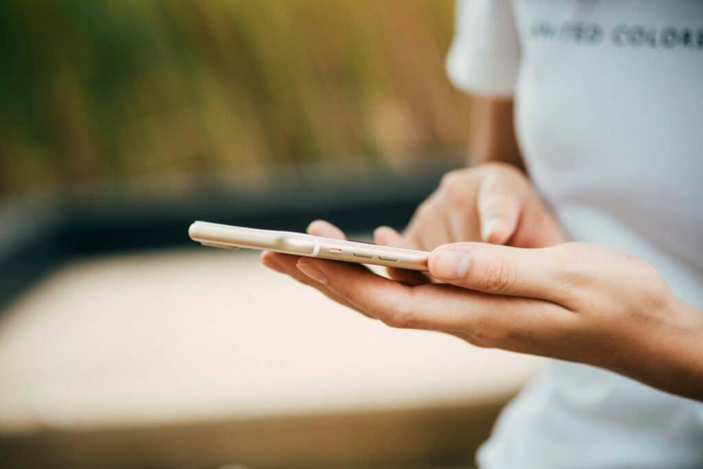 Eine Frau mit einem Smartphone an der Hand.