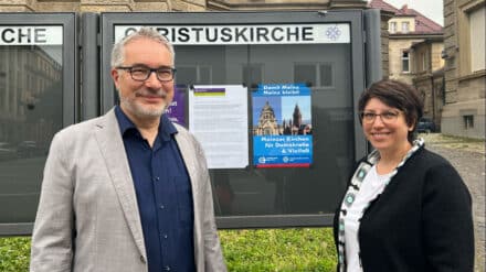 Pfarrerin Eva Lemaire und Dekan Andreas Klodt vor dem Schaukasten der Christuskirche Mainz.