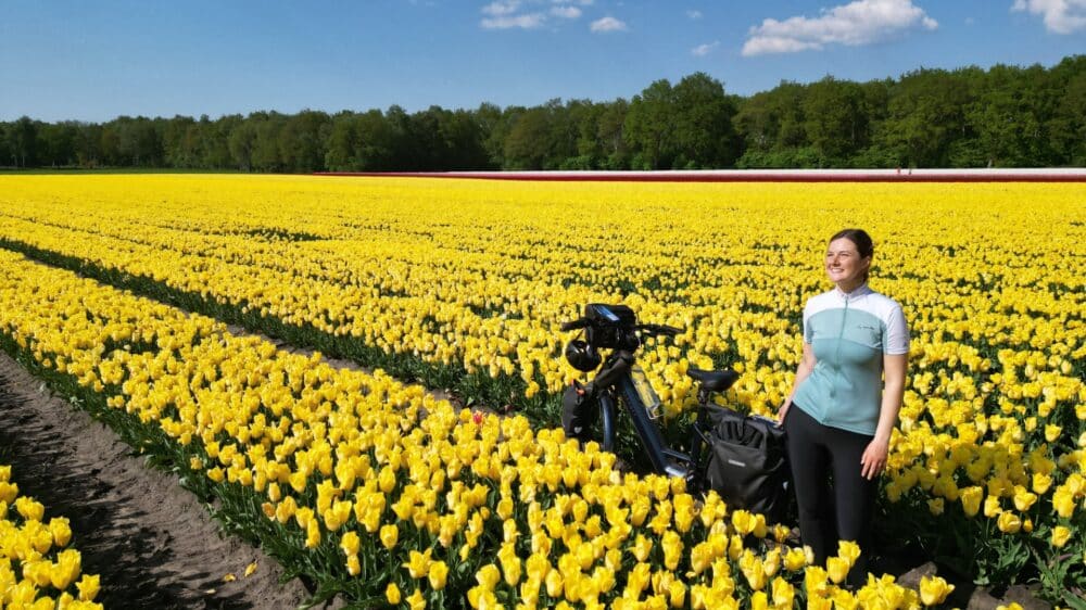 Carola Mehltretter auf einem Feld voller Blüten mit ihrem E-Bike