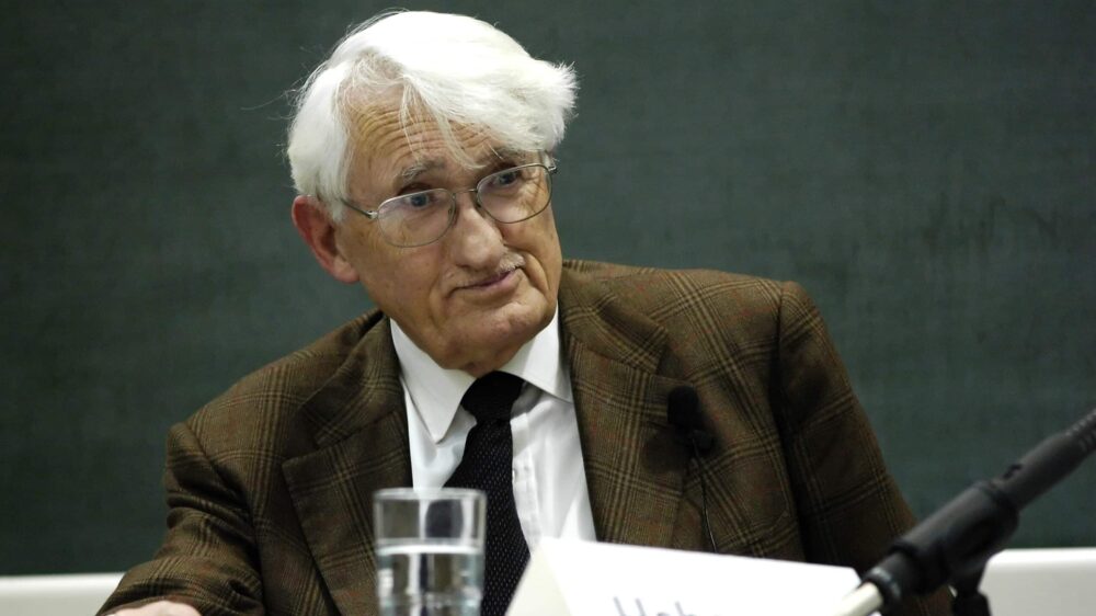 Jürgen Habermas sitzt an einem Tisch, vor ihm ein Mikrofon und ein Wasserglas