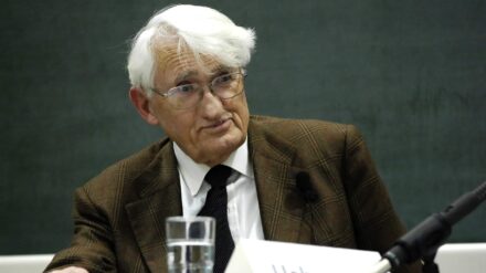 Jürgen Habermas sitzt an einem Tisch, vor ihm ein Mikrofon und ein Wasserglas