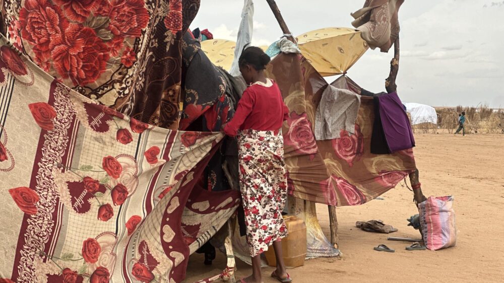 Eine Binnenvertriebene vor provisorischem Zelt im Sudan