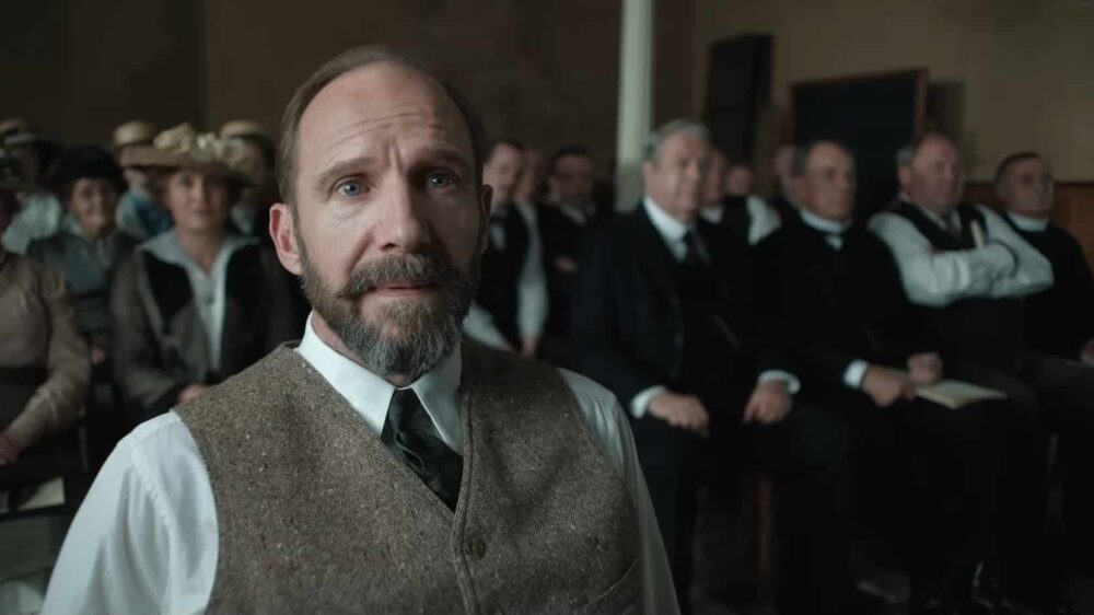 Ralph Fiennes lauscht einer schwarzen Sängerin beim Vorsingen im Film „The Choral“