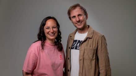 Dina Ketzer und Pierre-Schwering in der Halbtotalen, sie lächeln freundlich in die Kamera