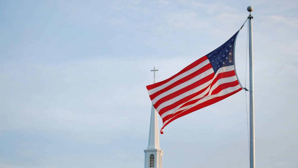 Eine USA-Fahne, im Hintergrund eine Kirche