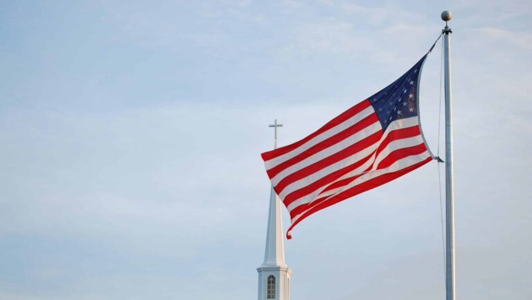 Eine USA-Fahne, im Hintergrund eine Kirche